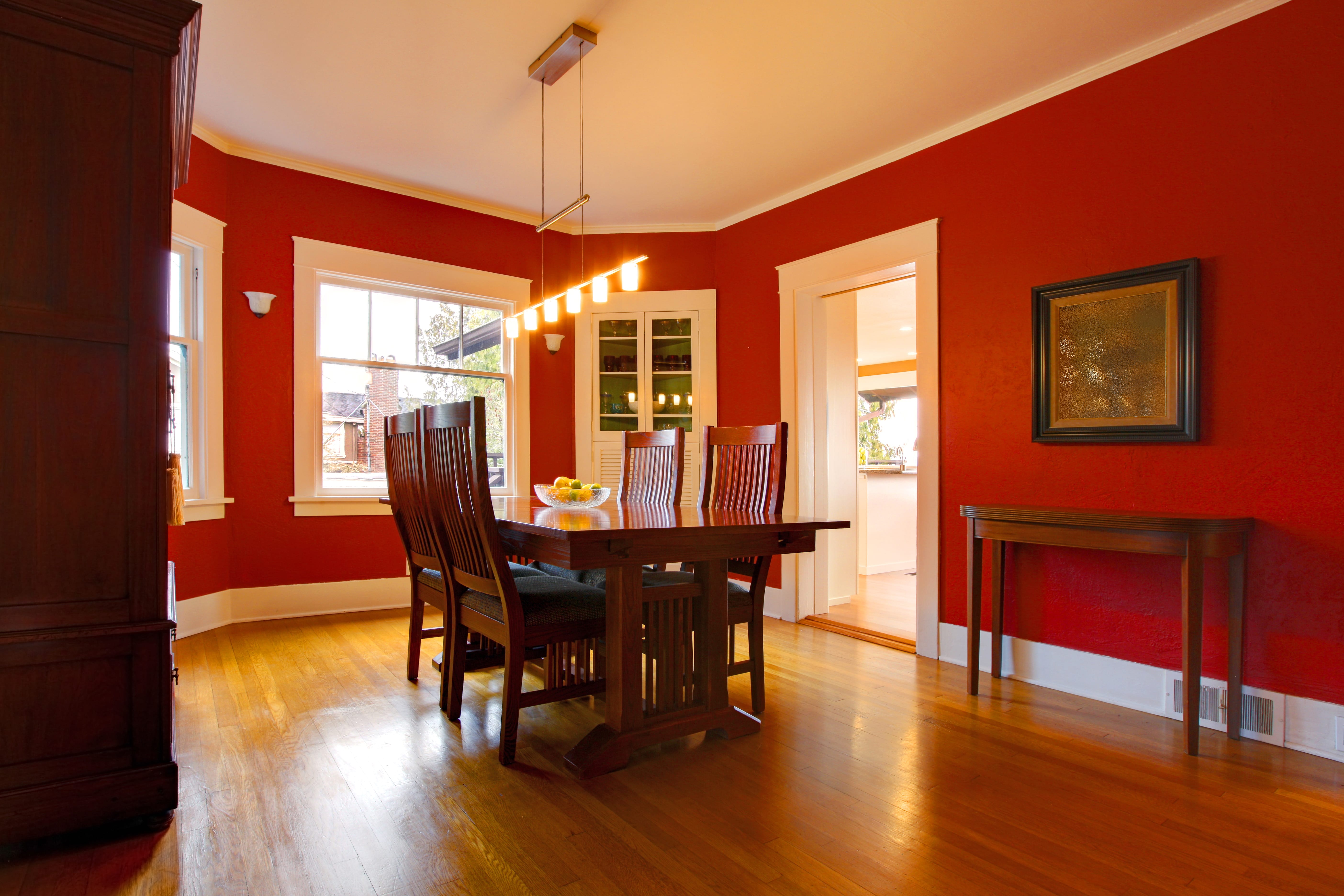 яркая столовая комната с красными обоями на стенах